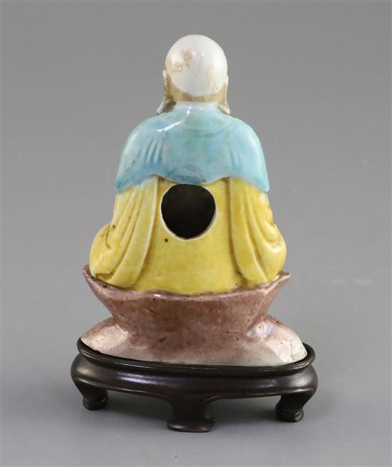 A Chinese enamelled biscuit seated figure of Buddha, 18th/19th century, H. 9.5cm, wood stand